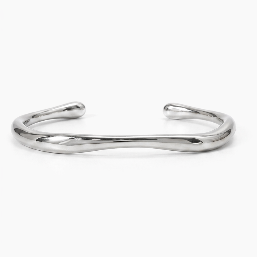 Close-up of the left end of a gold-plated stainless steel cuff bracelet, highlighting its smooth, organic curves.