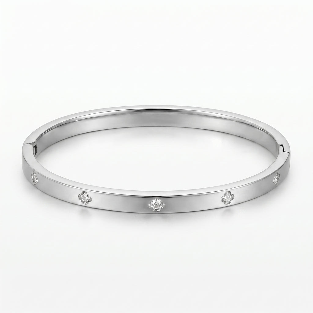 Woman wearing a gold-tone titanium steel Eclipse Bangle with sparkling zircon embellishments, paired with an orange top and matching gold necklace.