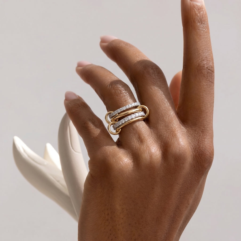 Model's hand wearing the exquisite Linked Pavé Diamond Ring, highlighting the two-tone gold and diamond design in a natural, luxurious setting.