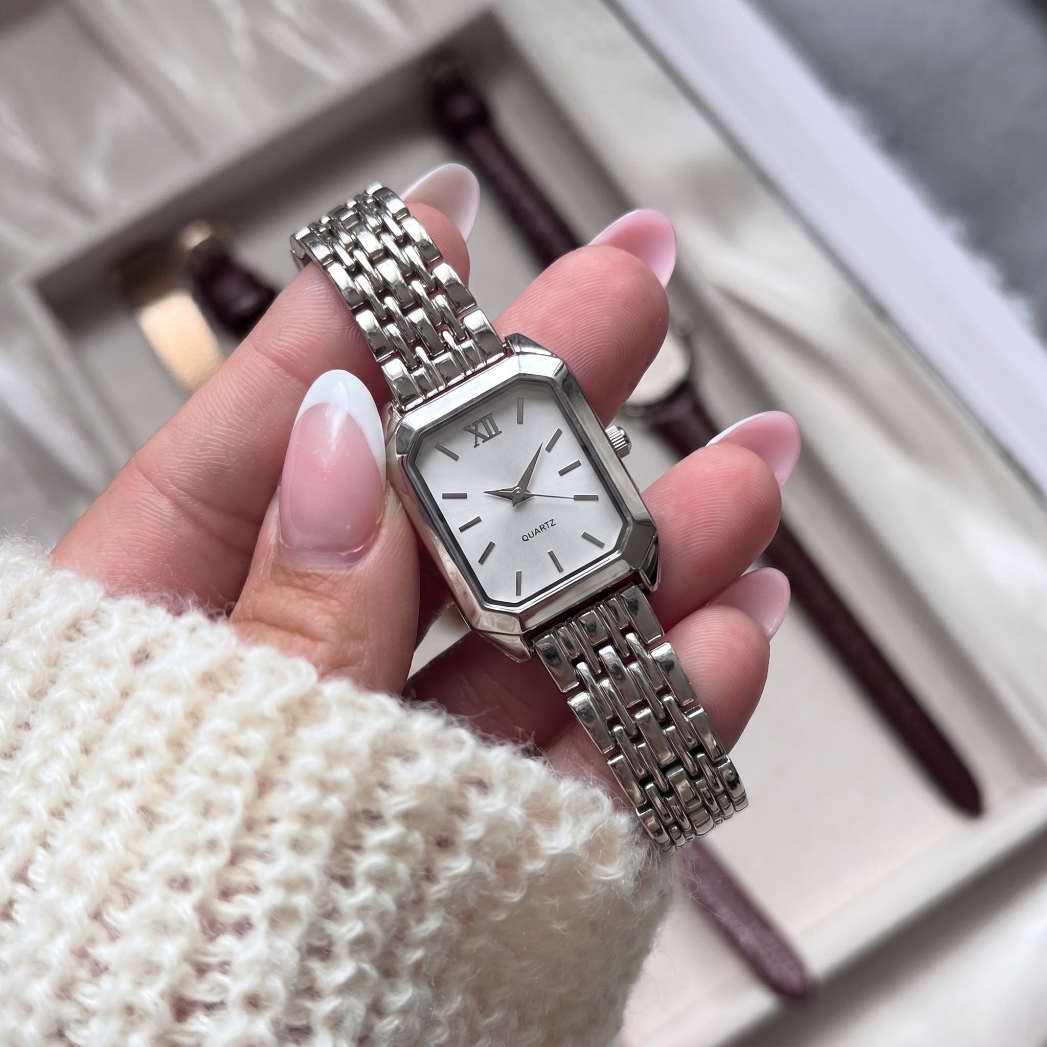 Silver-tone Radian Square Quartz Watch with white dial, held by hand, highlighting refined craftsmanship