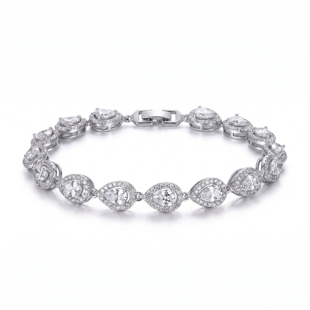 A woman's arm wearing a sparkling rhodium-plated bracelet featuring pear-cut zircon stones, each framed by a pave halo, exuding refined elegance.