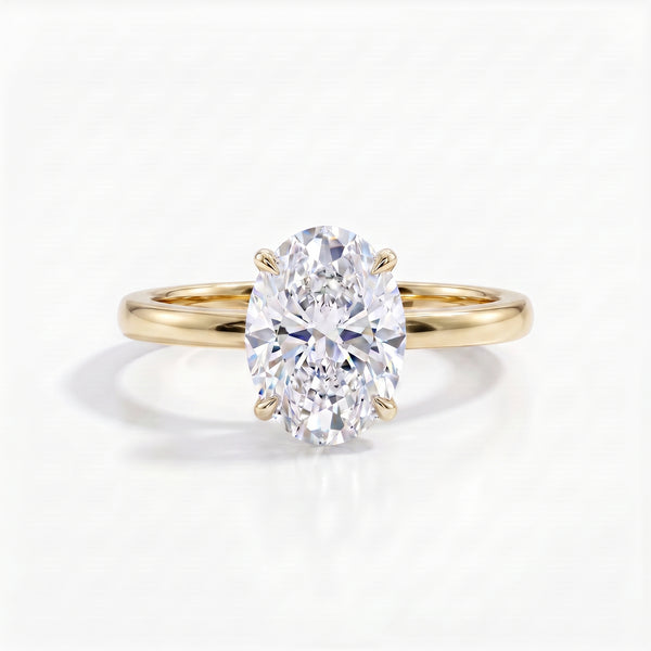 A radiant oval-cut diamond solitaire ring set in a polished 18k yellow gold band, casting a soft shadow on a pristine white surface.