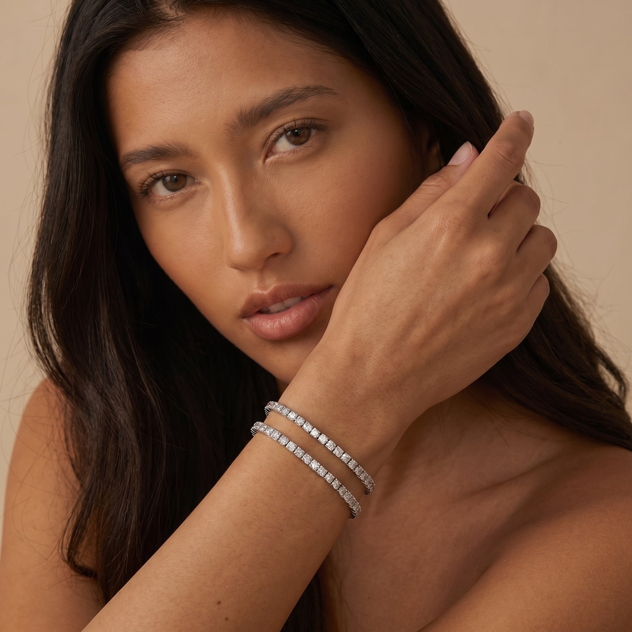 Model wearing two exquisite zirconia tennis bracelets, highlighting their radiant beauty and versatile styling on the wrist against a neutral background.