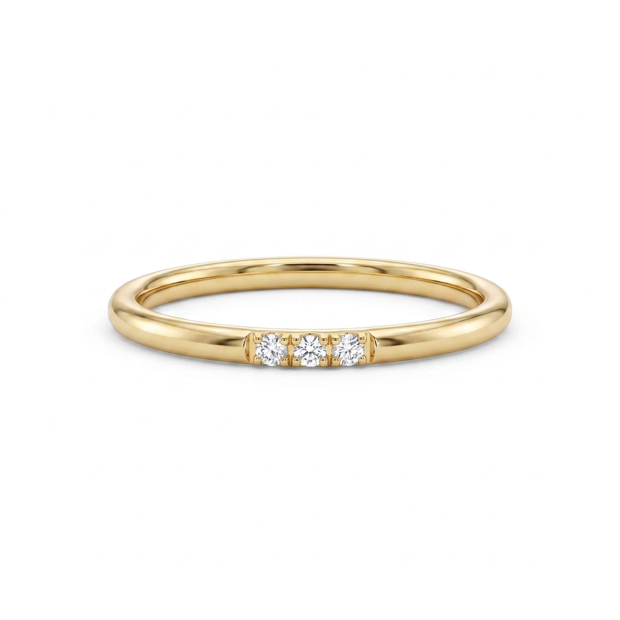 A minimalist 14k yellow gold diamond trio band ring displayed on a pristine white background