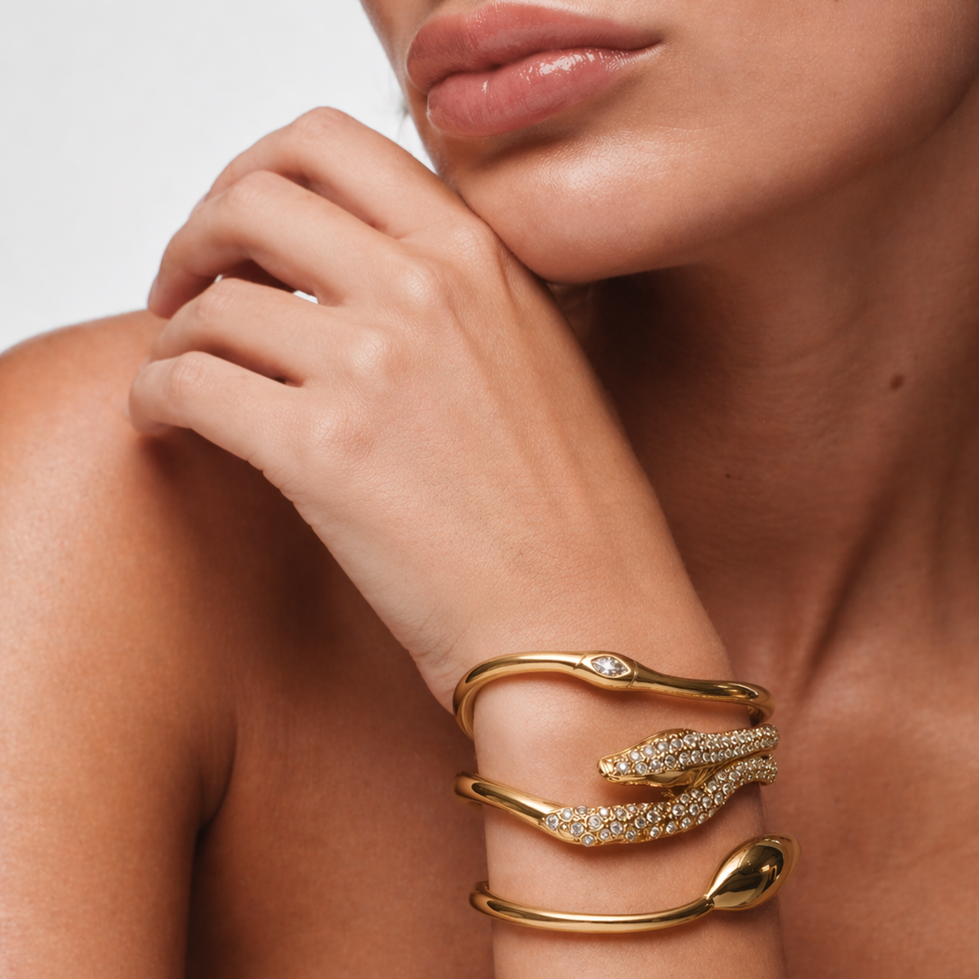 Gold-plated stainless steel infinity snake bangle with marquise zircon eye on white background, luxury waterproof jewelry.
