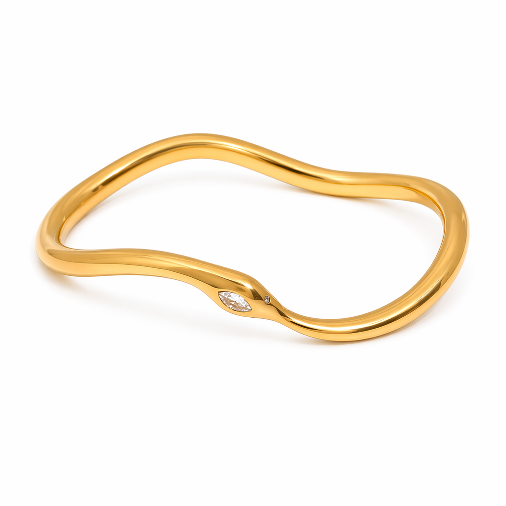 Model wearing stack of gold-plated stainless steel snake bangles, including infinity design with zircon eye, on wrist, fashionable affordable jewelry.