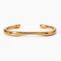 18K gold-plated stainless steel cuff bracelet with a fluid, organic design. Reflective, waterproof, and affordable jewelry.
