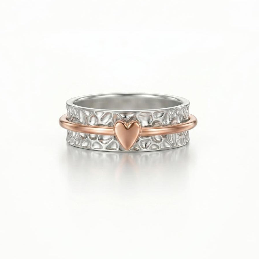 Silver ring with a heart charm on a white background